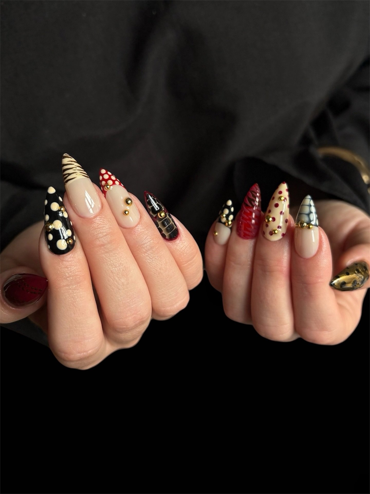 Black and Nude Almond Nails with Gold and Red Accents
