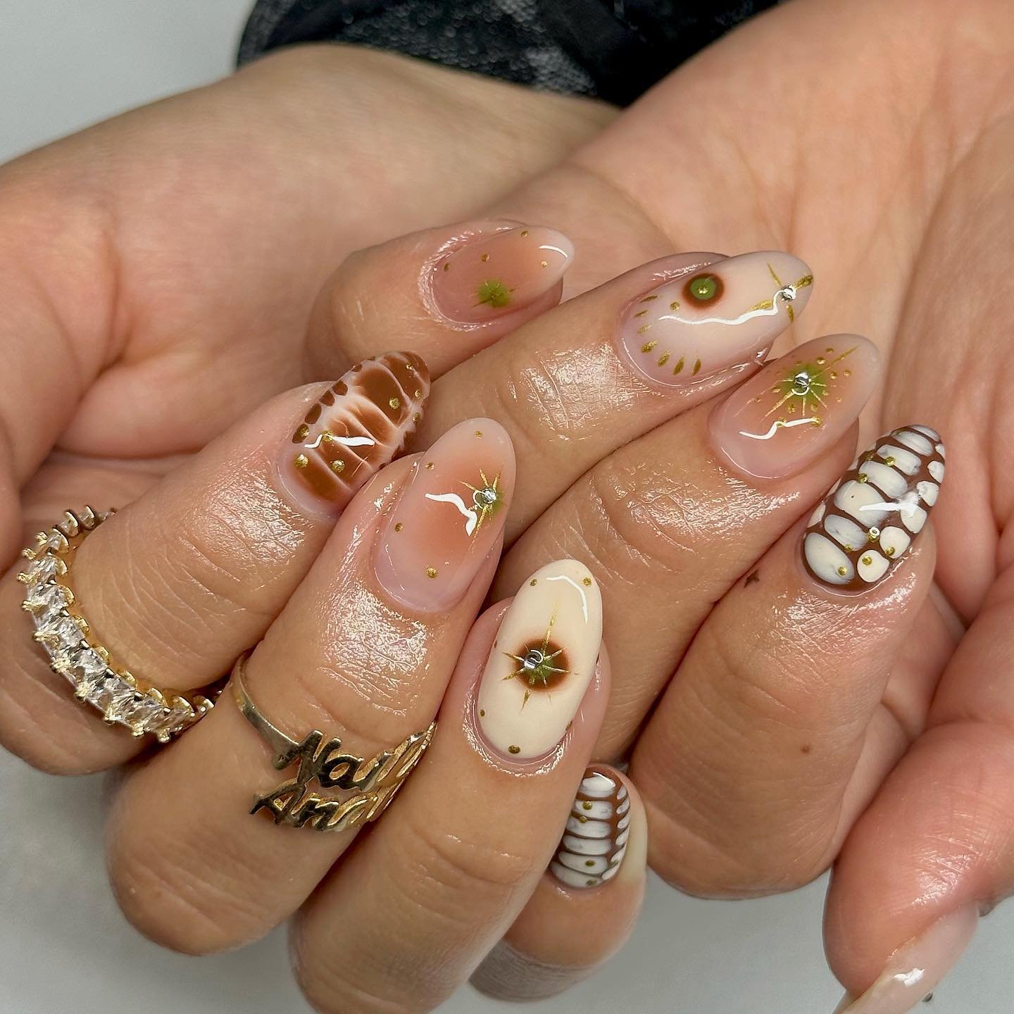 Sheer Nude Almond Nails with Gold, Cream, and Green Details