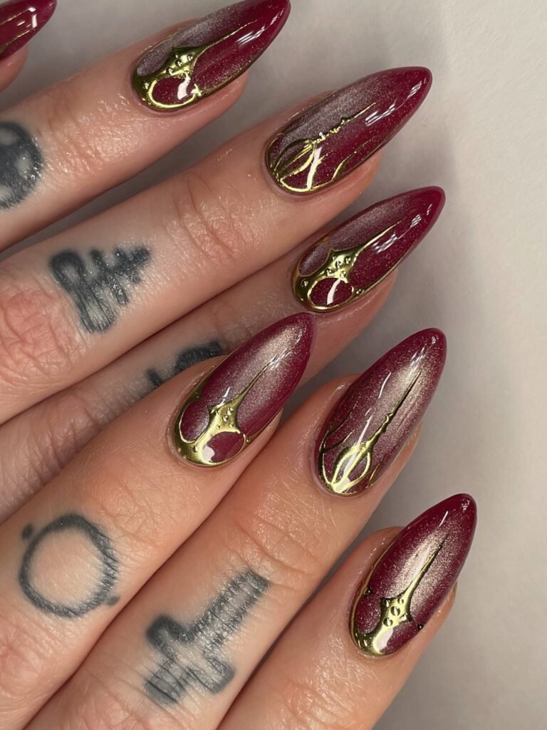 Deep Burgundy Almond Nails with Gold Abstract Accents