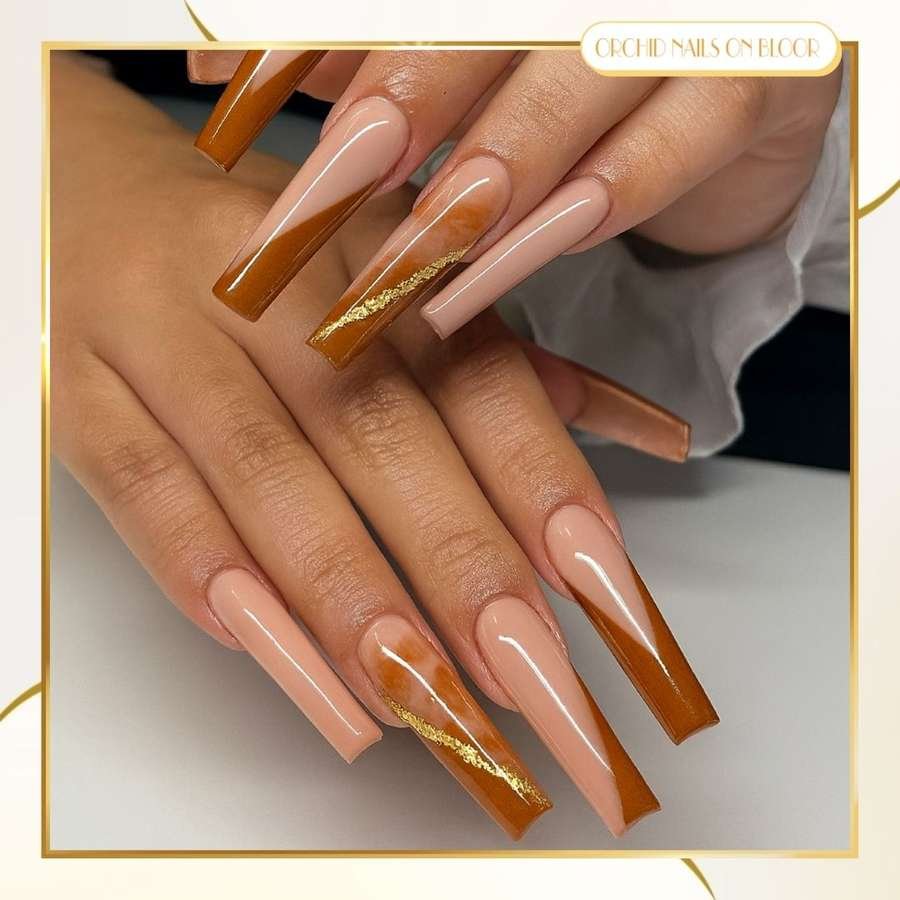 Long Nude Nails with Brown French Tips and Gold Accents