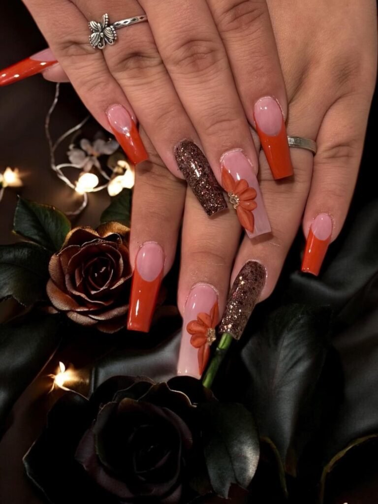 Long Orange French Tips with Floral and Dark Accents nail design