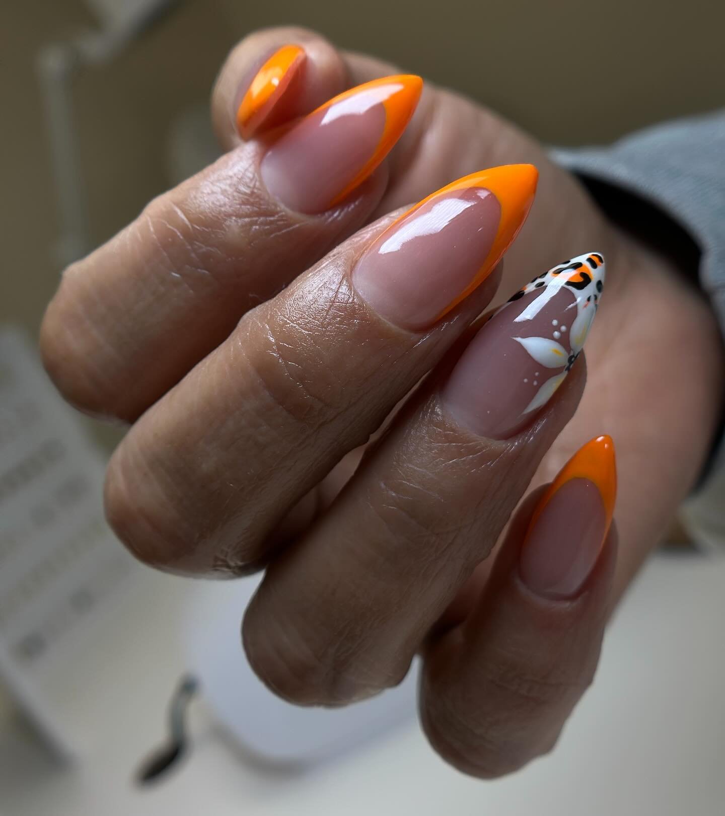 Glossy Orange French Tips with a Black-and-White Accent nail design