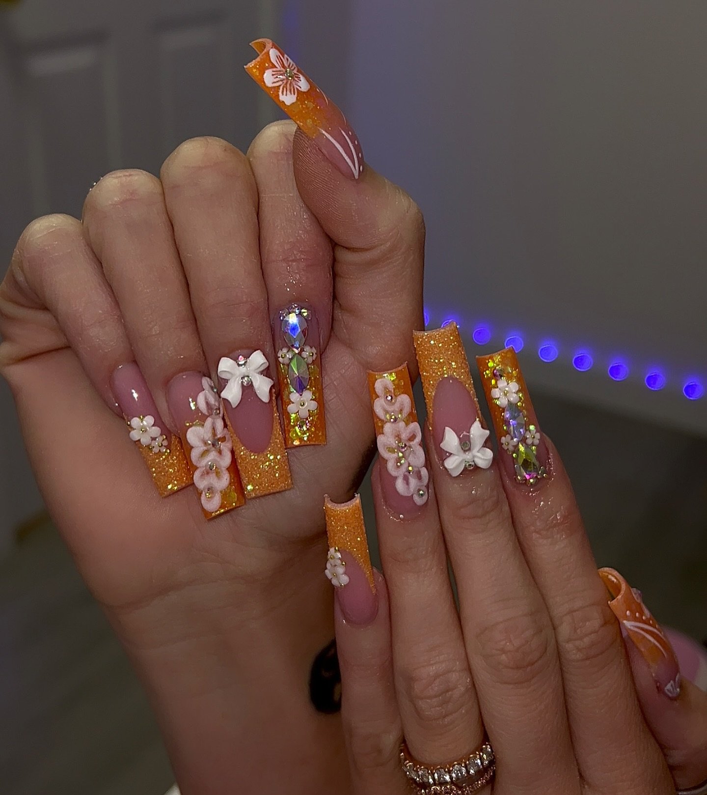 Orange French Tips with Glitter and Floral Embellishments nail design