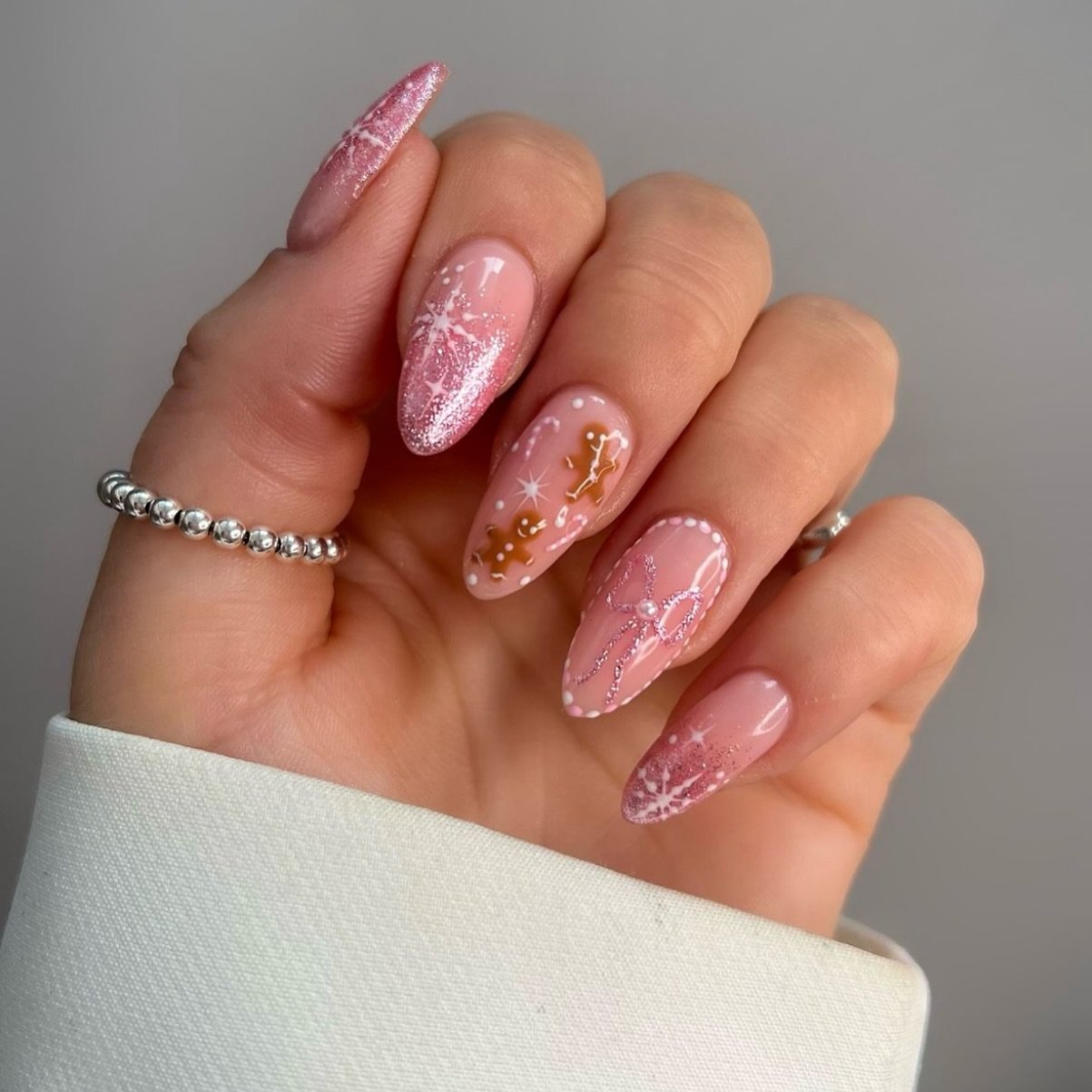 Pink Glitter Almond Nails with White Swirls and Gold Accents