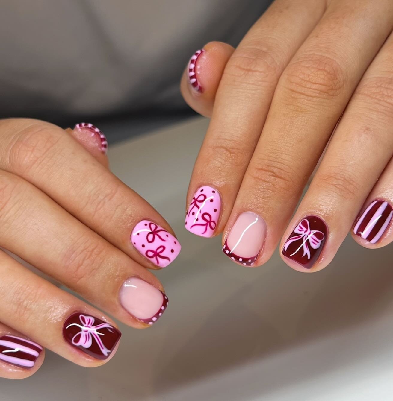 Short Pink Christmas Nails with Bows and Striped Accents
