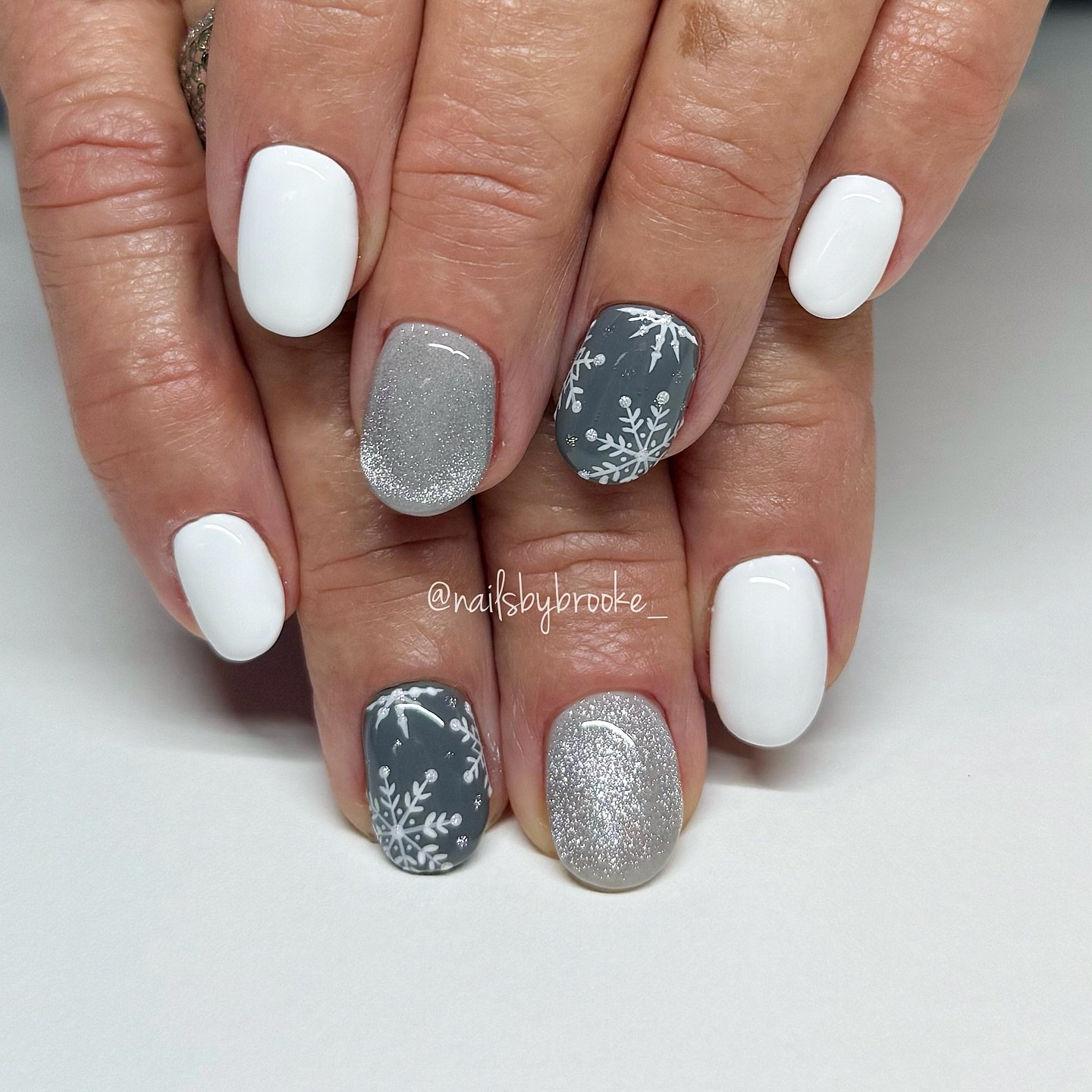 Silver Christmas nails idea 21: White and Silver Short Nails with Snowflake Patterned Accents