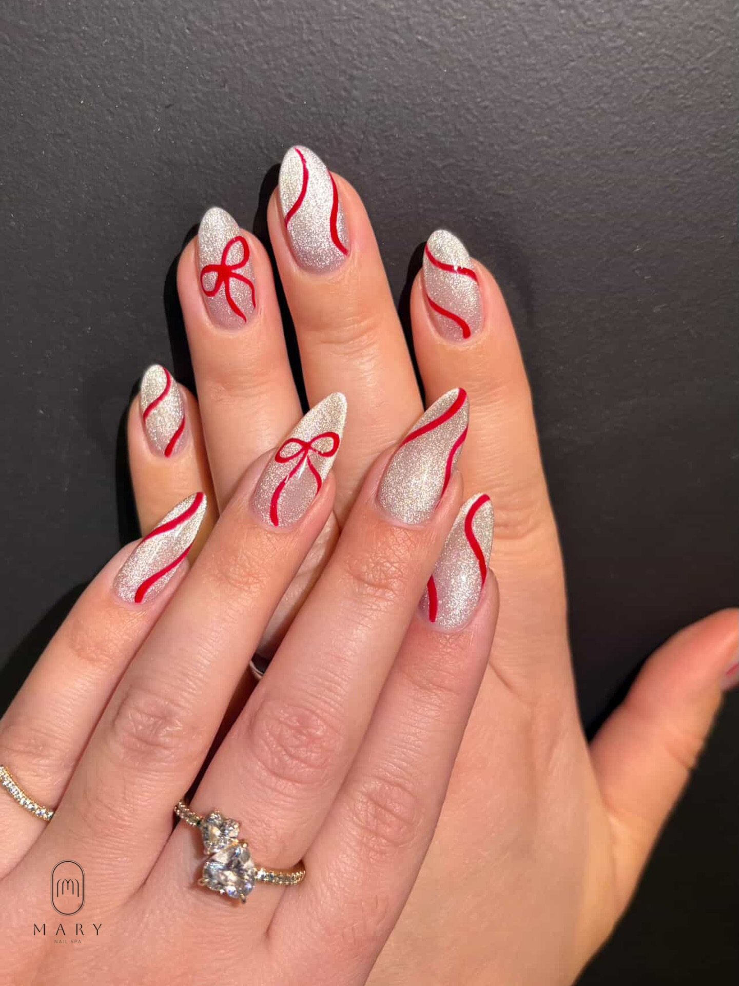 Silver Christmas nails idea 29: Pink Nails with Silver Glitter and Bow Accents