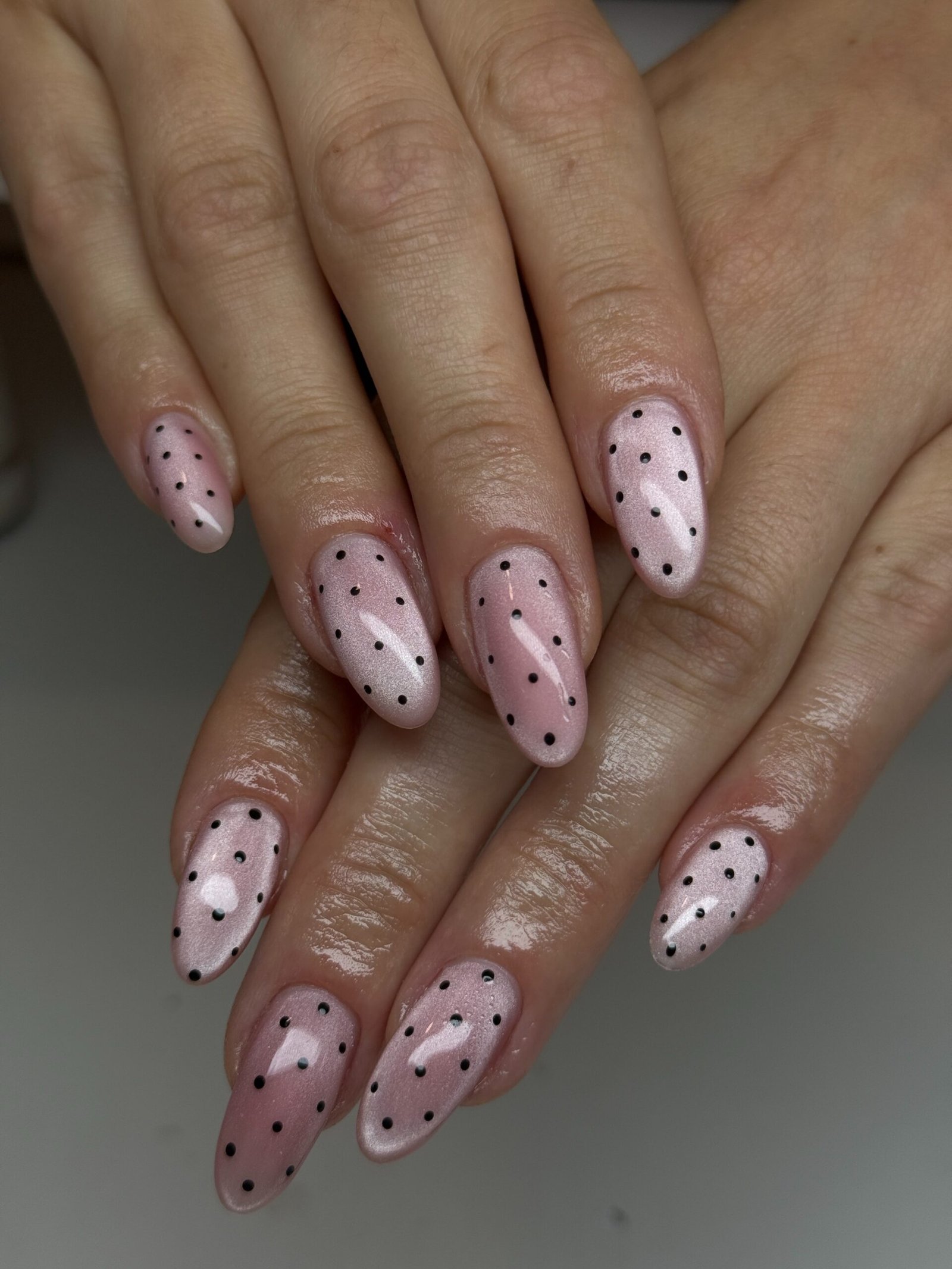 Long almond nails use a soft nude-pink base with fine silver details and small sparkling embellishments.