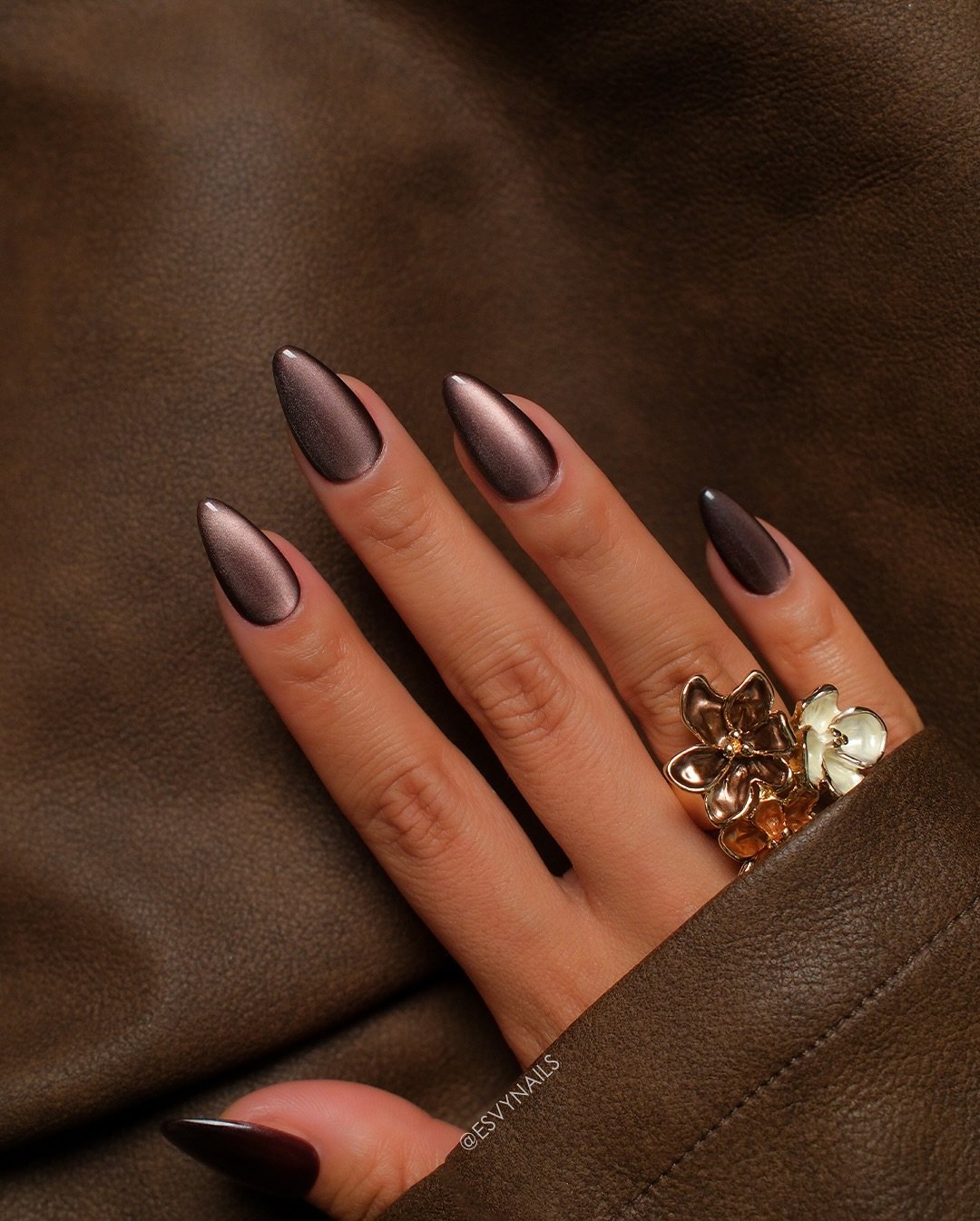 Short-to-medium oval nails feature a translucent pink base with a vivid iridescent glow and bright reflective centers.
