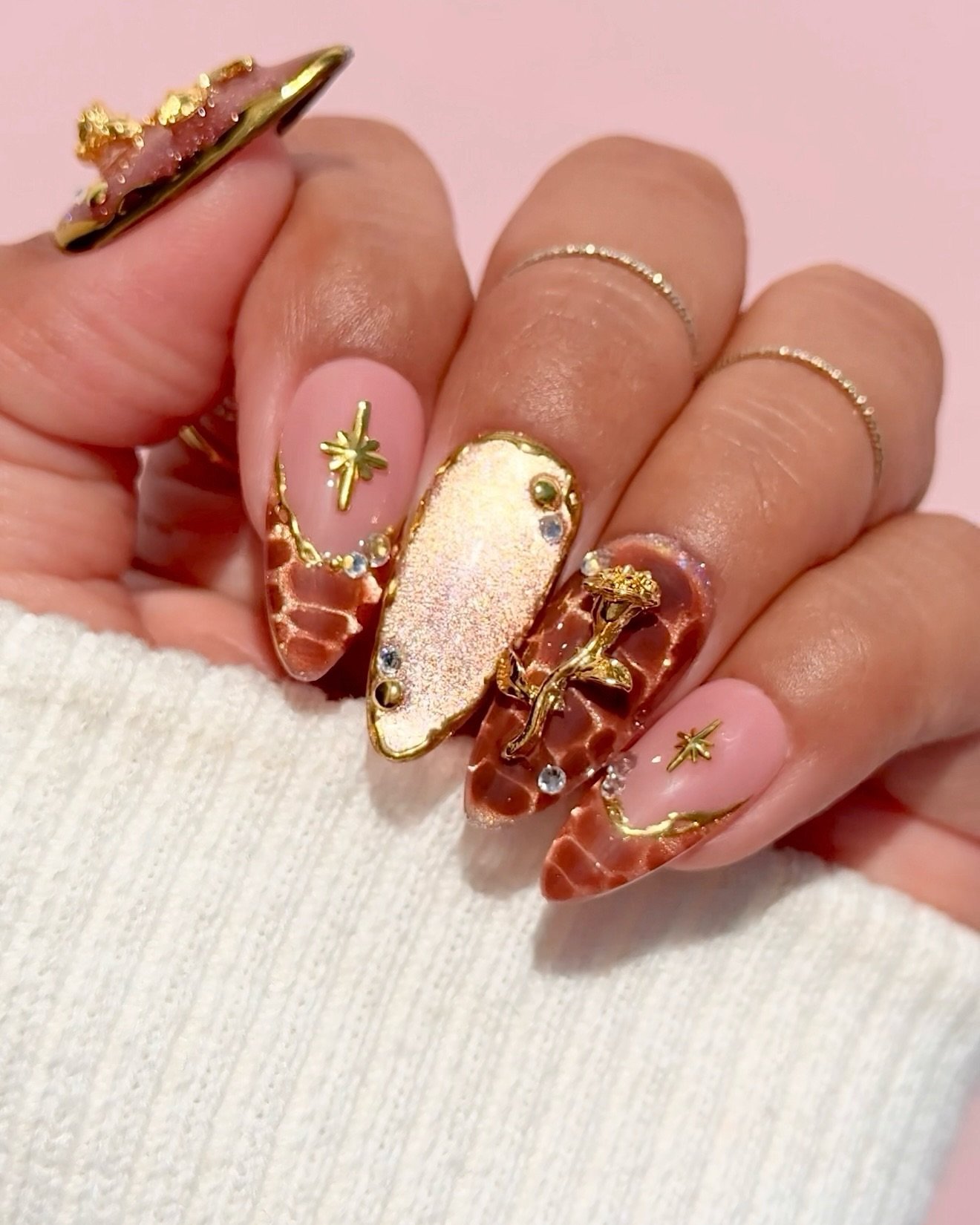 Long almond nails are glossy cobalt blue with white starburst and curved-line accents across several nails.