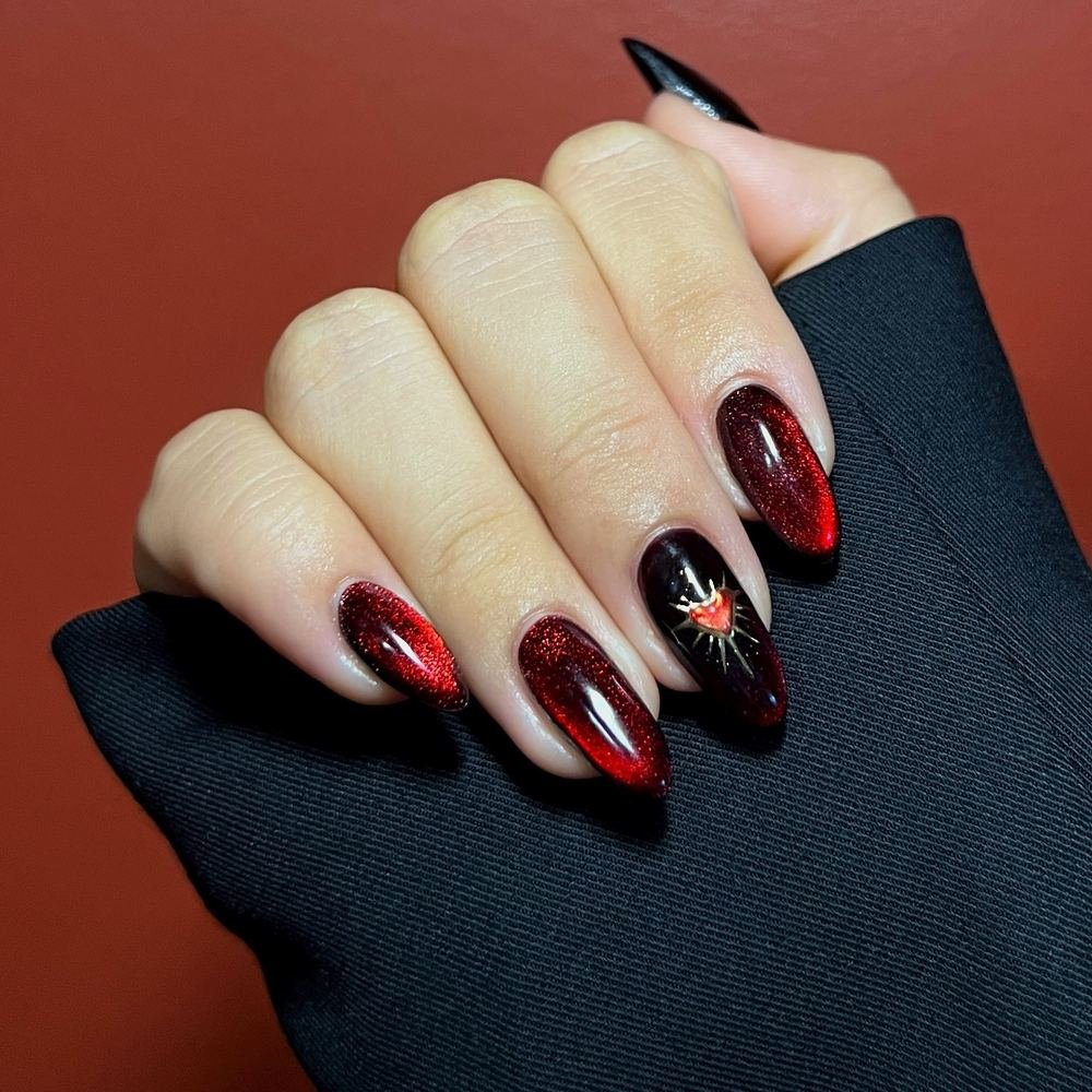 Glossy Black and Red Almond Nails with a Star Accent