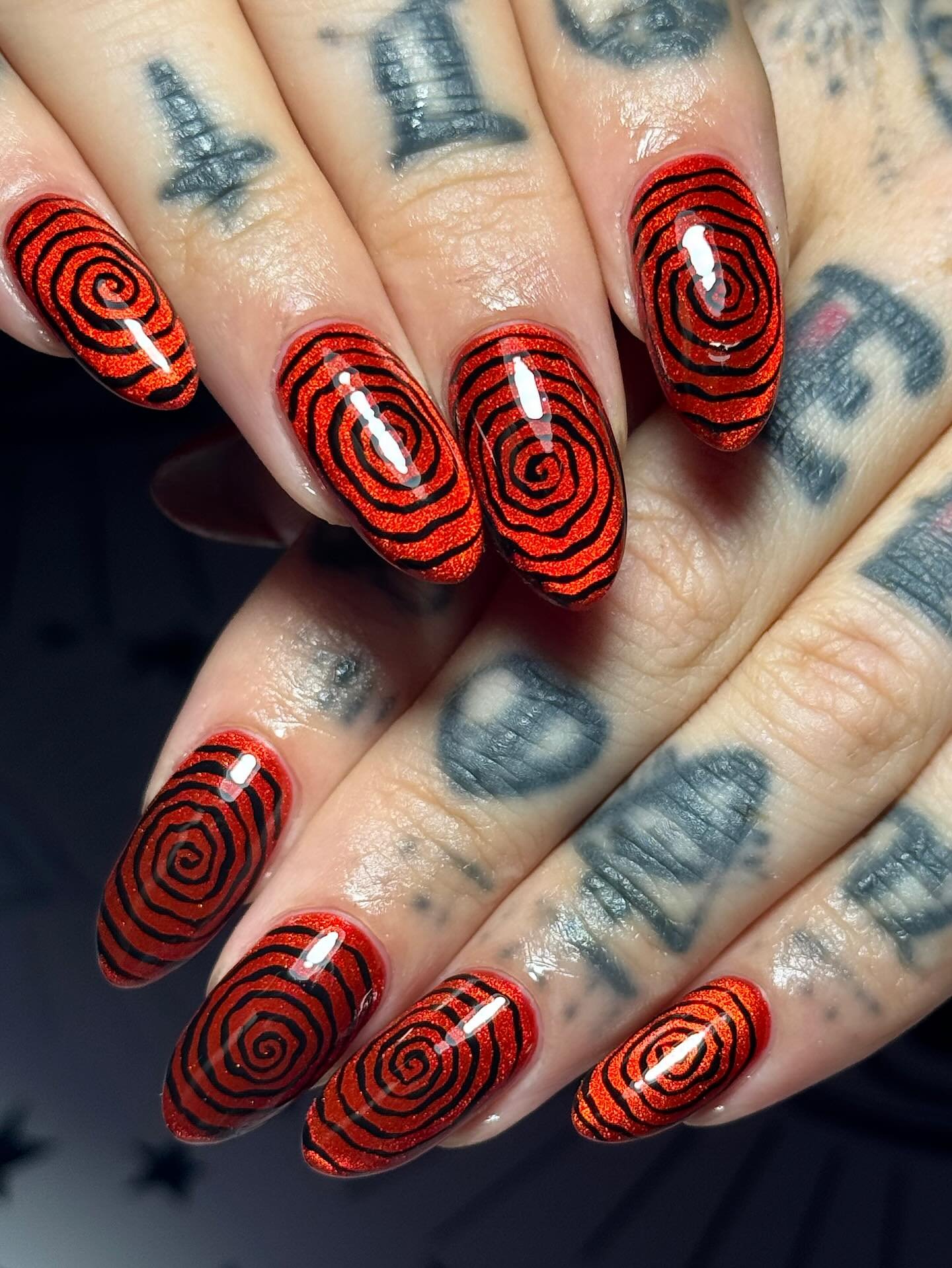 Red Nails with Concentric Black-and-White Spiral Designs