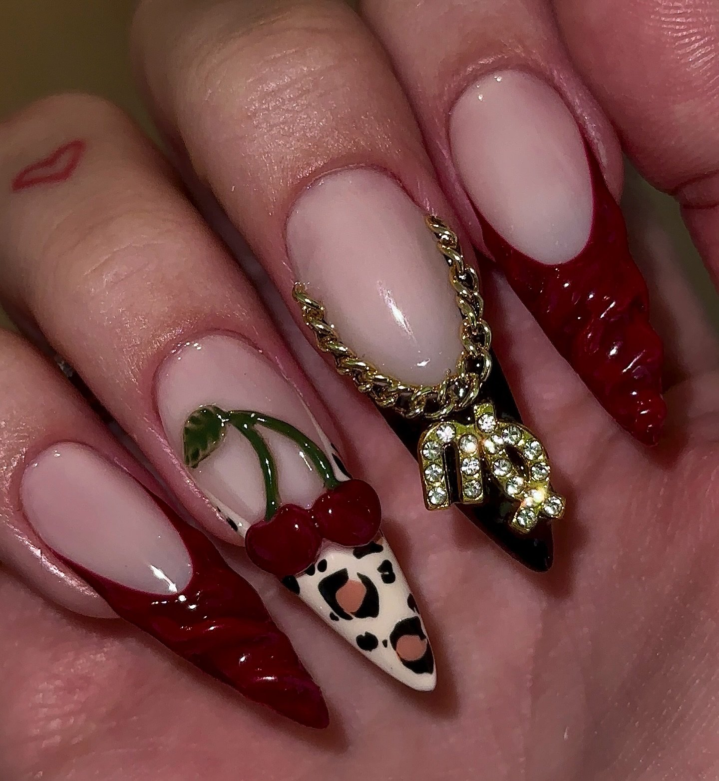 Blush and Deep Red Stiletto Nails with Cow-Print Accent