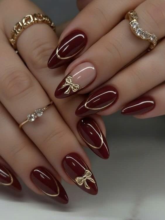 Deep wine almond nails with gold accents