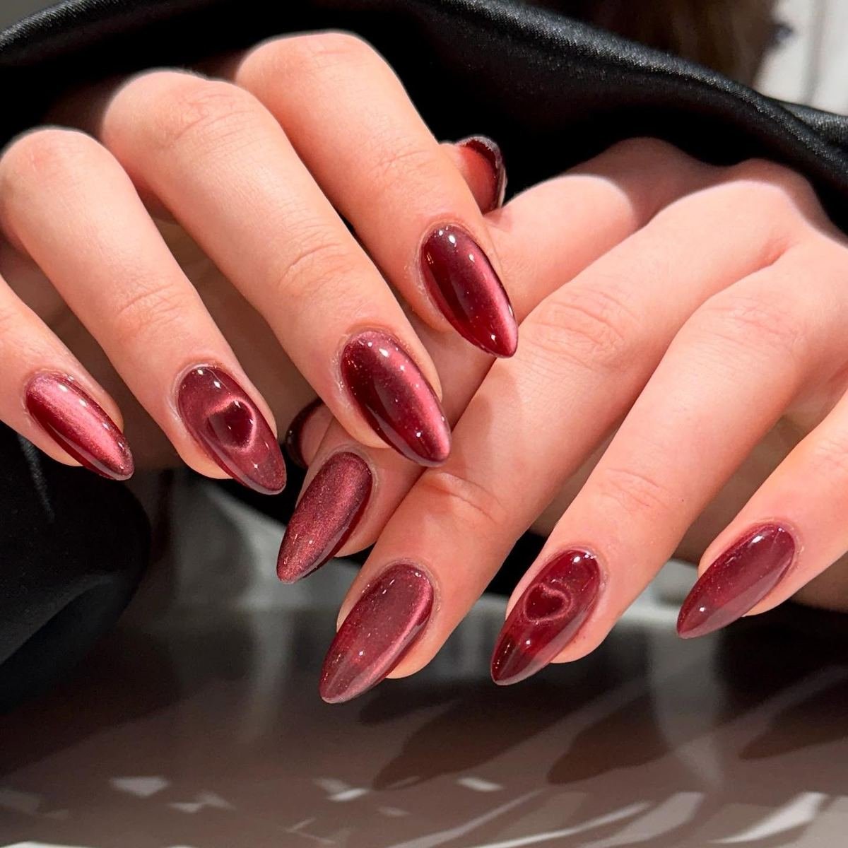 Glossy wine almond nails with varied accents